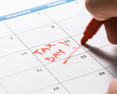 Man marking down tax day on calendar