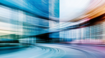 Blurred motion of train near office building.