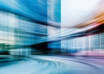 Blurred motion of train near office building.