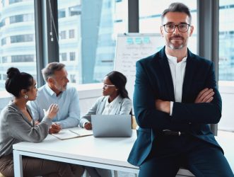 Portrait, arms crossed and business man, ceo or entrepreneur in meeting. Face, professional glasses and serious executive, mature leader or manager with confidence, pride for career and leadership